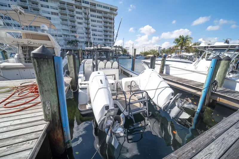 Slide: The Image of 2022 World Cat 400 CC-X docked at marina, surrounded by boats and waterfront buildings. - 2