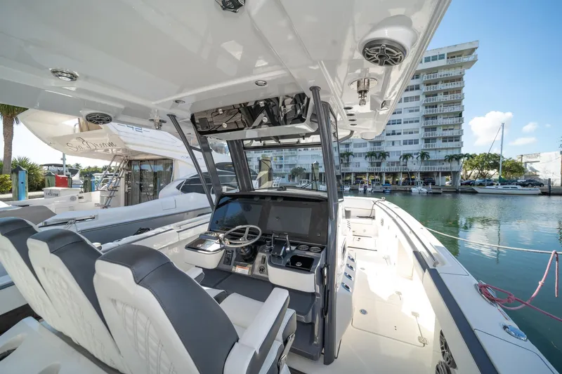 Slide: The Image of 2022 World Cat 400 CC-X boat interior with modern helm, docked near waterfront buildings. - 21