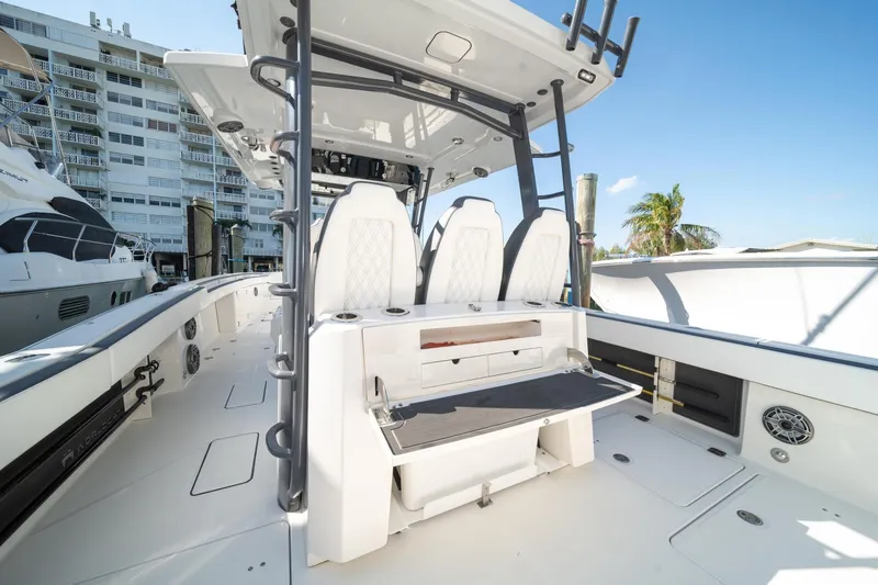 Slide: The Image of 2022 World Cat 400 CC-X boat interior with seating and storage, docked near buildings. - 29