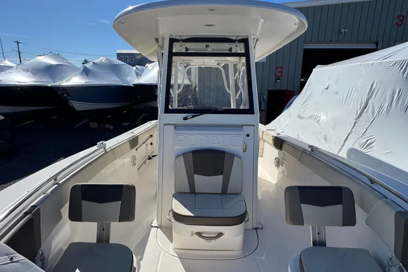 Slide: The Image of 2019 Robalo R272 Center Console boat with seating, docked near covered vessels. - 20