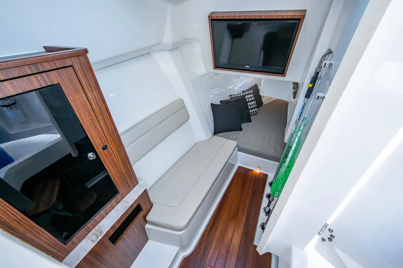 Slide: The Image of 2019 Pursuit DC 365 Dual Console cabin with seating, TV, and wooden accents. - 12