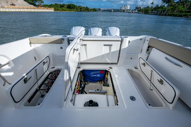 Slide: The Image of 2019 Pursuit DC 365 Dual Console boat with open storage compartments on deck. - 15