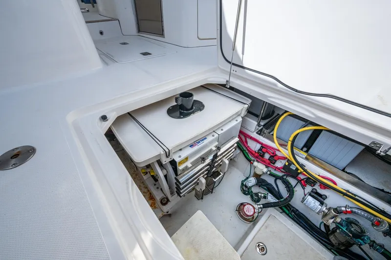 Slide: The Image of 2019 Pursuit DC 365 Dual Console boat storage compartment with wiring and equipment. - 23
