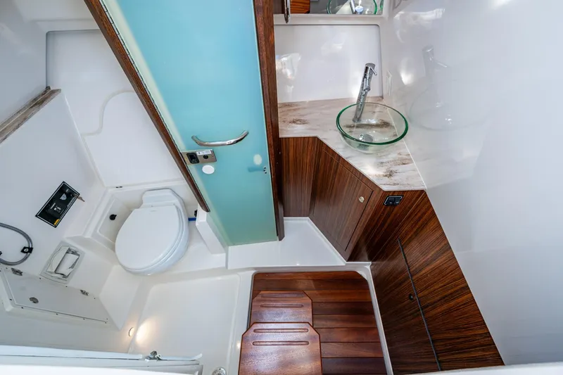 Slide: The Image of 2019 Pursuit DC 365 Dual Console boat bathroom with modern design and wooden accents. - 27
