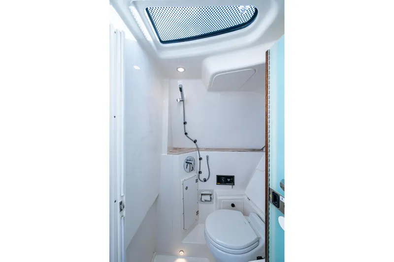 Slide: The Image of 2019 Pursuit DC 365 Dual Console boat bathroom with skylight and modern fixtures. - 28
