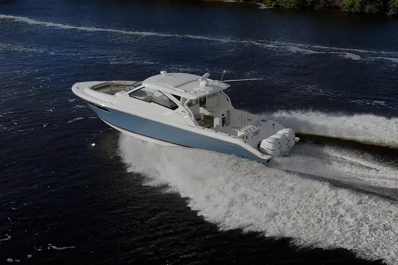 Slide: The Image of 2019 Pursuit DC 365 Dual Console boat cruising on open water. - 3