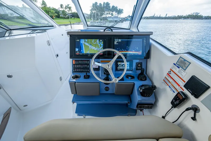 Slide: The Image of 2019 Pursuit DC 365 Dual Console boat dashboard with navigation screens and controls. - 36