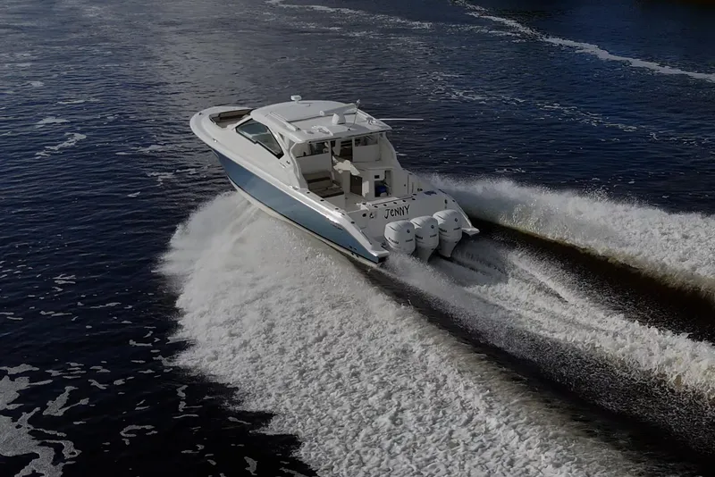 Slide: The Image of 2019 Pursuit DC 365 Dual Console boat cruising on open water. - 4