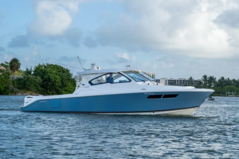 Slide: The Image of 2019 Pursuit DC 365 Dual Console boat cruising on a calm waterway. - 41