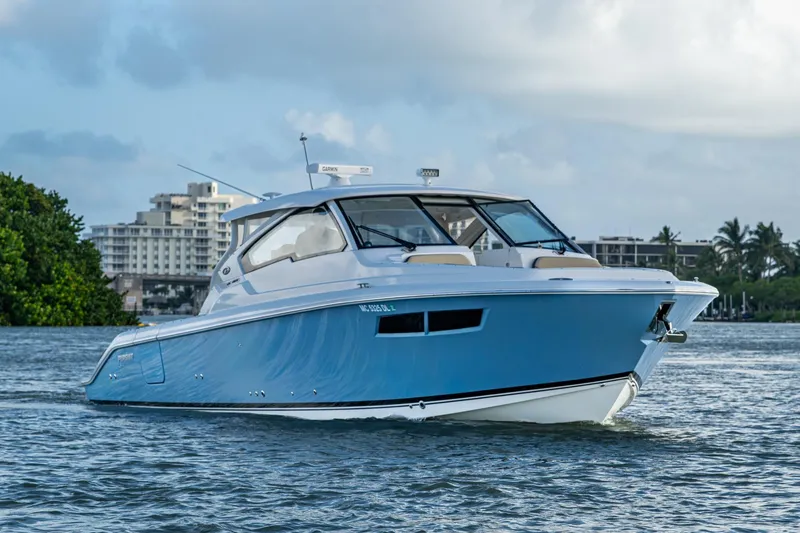 Slide: The Image of 2019 Pursuit DC 365 Dual Console boat on water, cityscape background. - 42