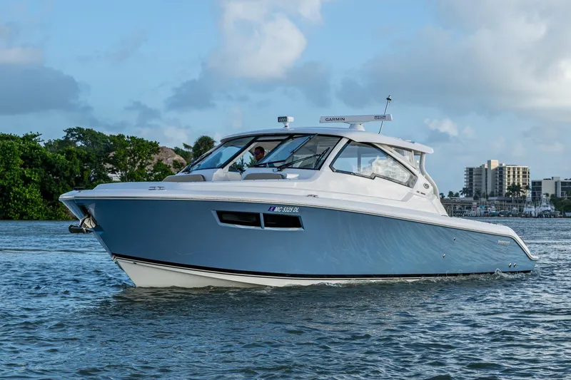 Slide: The Image of 2019 Pursuit DC 365 Dual Console boat cruising on a calm waterway. - 44
