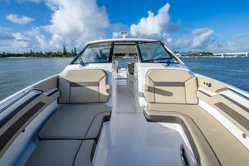 Slide: The Image of 2019 Pursuit DC 365 Dual Console boat interior with spacious seating on a sunny day. - 7
