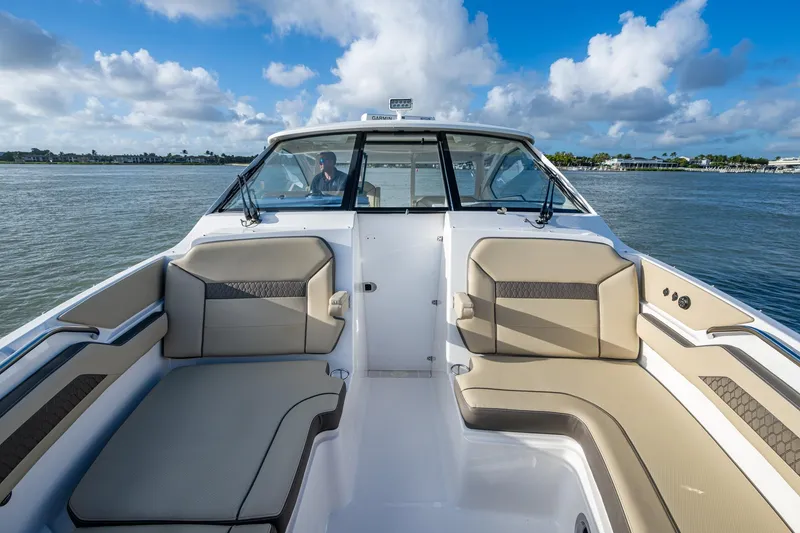 Slide: The Image of 2019 Pursuit DC 365 Dual Console boat interior with beige seating on a sunny day. - 8