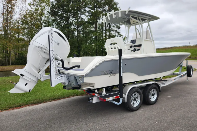 Slide: The Image of 2026 Pathfinder 2400 TRS boat on trailer, parked outdoors, featuring sleek design and powerful engine. - 2