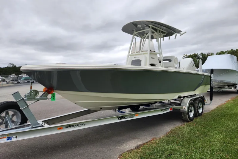 Slide: The Image of 2026 Pathfinder 2400 TRS boat on trailer, parked outdoors under cloudy sky. - 6