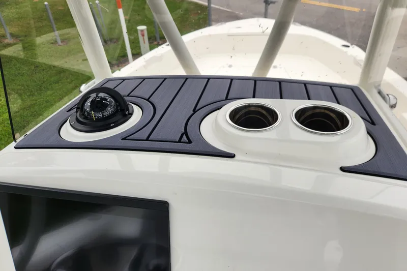 Slide: The Image of 2026 Pathfinder 2400 TRS boat dashboard with compass and cup holders. - 9