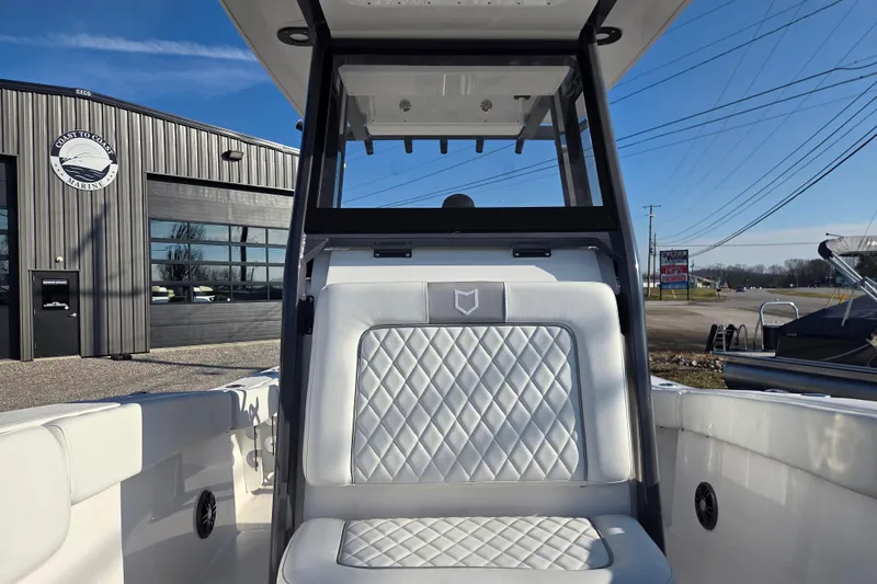 Slide: The Image of 2026 Sea Fox 228 Commander boat interior with diamond-stitched seating, parked outside Coast to Coast Marine. - 7