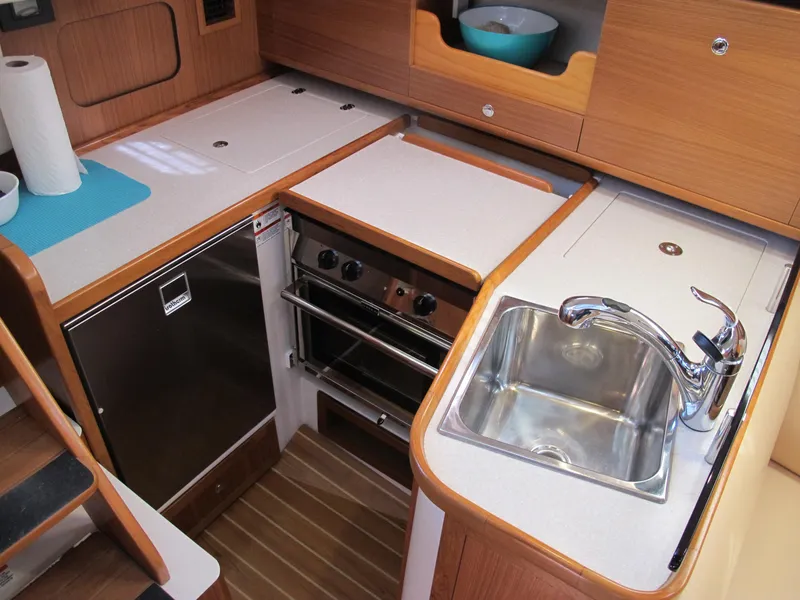 Slide: The Image of Modern kitchen area in a 2020 Catalina 315 sailboat with sink, stove, and refrigerator. - 18