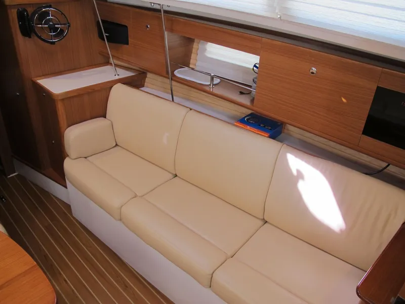 Slide: The Image of Interior of 2020 Catalina 315 sailboat with beige leather sofa and wooden cabinetry. - 23