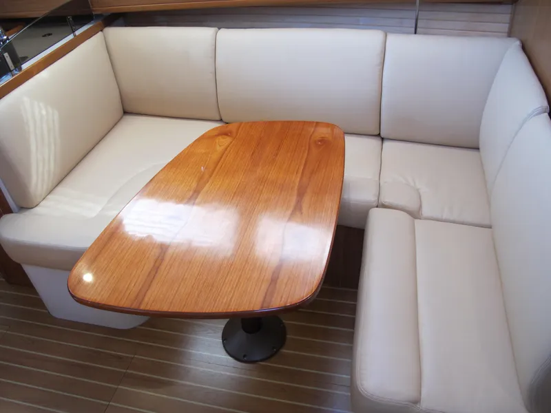 Slide: The Image of Catalina 315 2020 model interior with beige seating and wooden table. - 24