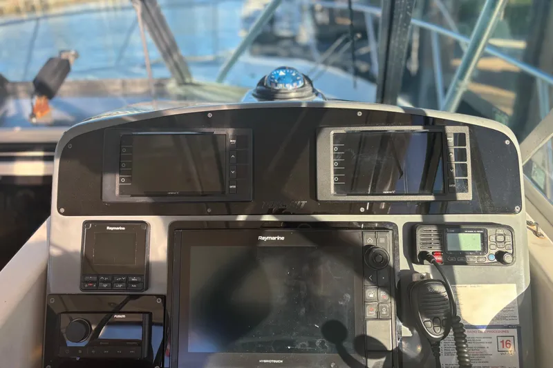 Slide: The Image of 2000 Pursuit 3400 Express boat docked by palm trees under clear blue sky. - 10