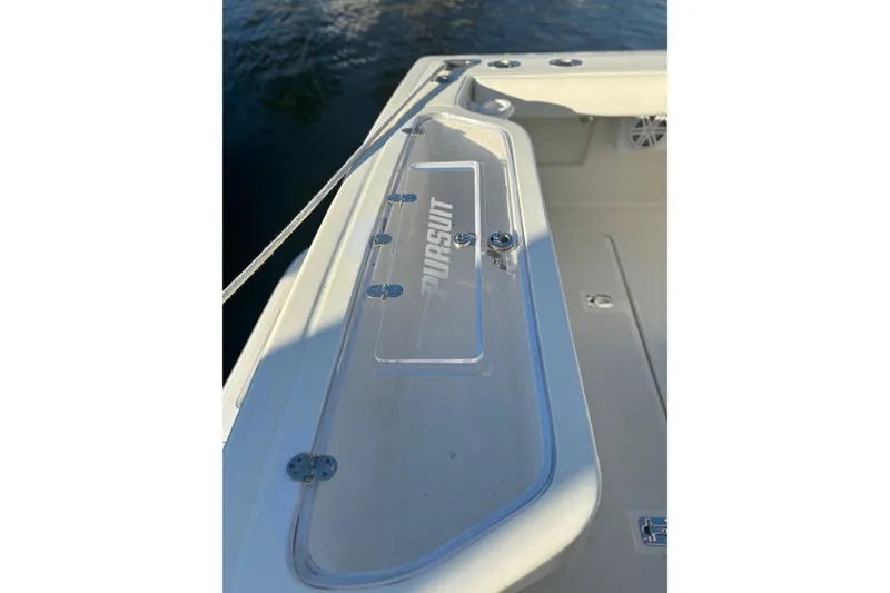 Slide: The Image of Helm of 2000 Pursuit 3400 Express boat with controls and steering wheel, docked by palm trees. - 19