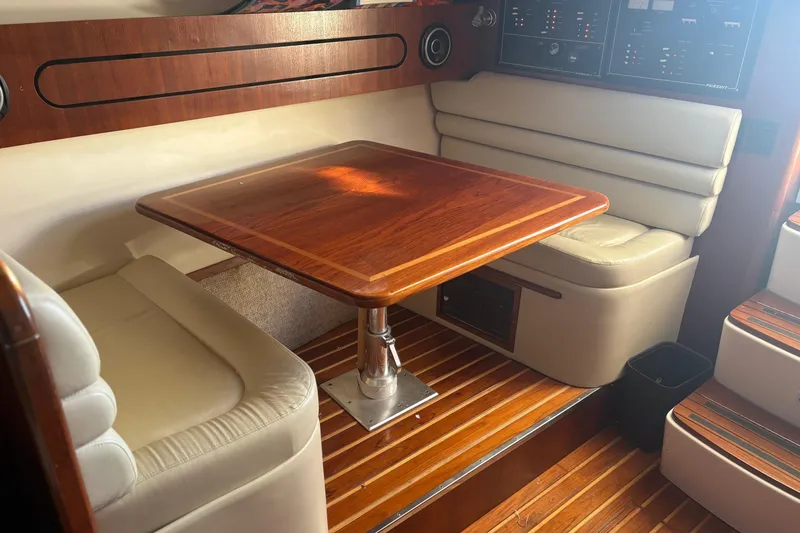 Slide: The Image of 2000 Pursuit 3400 Express boat docked by waterfront homes, featuring fishing equipment and sunny skies. - 24