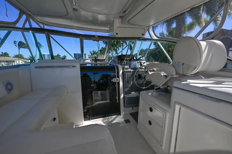 Slide: The Image of 2000 Pursuit 3400 Express boat interior with helm, seating, and dashboard under clear skies. - 30