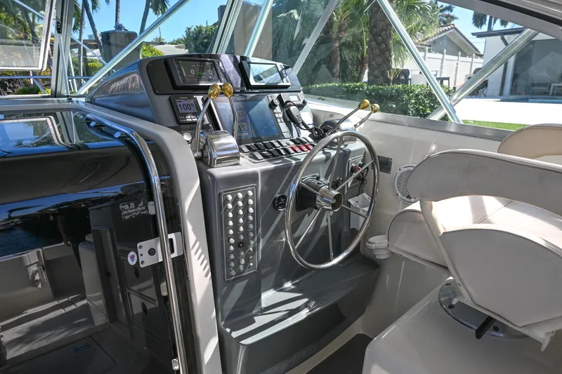 Slide: The Image of 2000 Pursuit 3400 Express boat cockpit with steering wheel and control panel. - 35