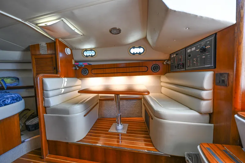 Slide: The Image of Interior of 2000 Pursuit 3400 Express boat with cozy seating and wooden accents. - 44