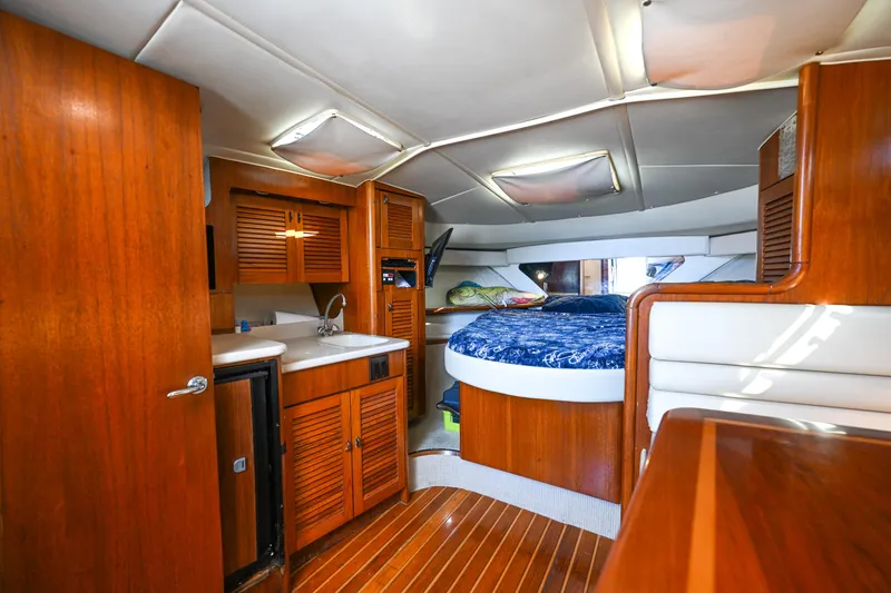 Slide: The Image of Interior of 2000 Pursuit 3400 Express boat with wood finish and cozy sleeping area. - 45