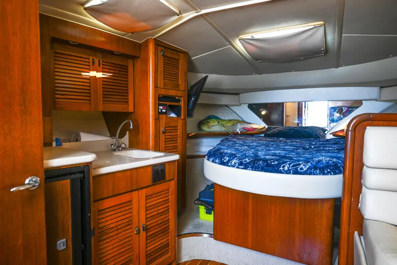 Slide: The Image of Interior of 2000 Pursuit 3400 Express boat with cozy cabin and wooden cabinetry. - 46