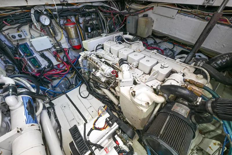 Slide: The Image of Engine room of a 2000 Pursuit 3400 Express boat, showcasing complex machinery and wiring. - 50