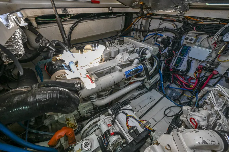 Slide: The Image of Engine room of a 2000 Pursuit 3400 Express boat, showcasing complex machinery and wiring. - 51