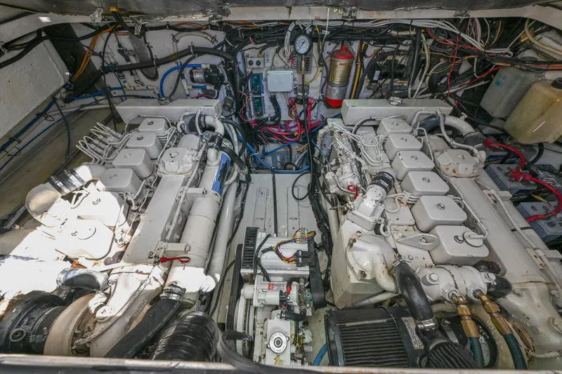 Slide: The Image of Engine room of a 2000 Pursuit 3400 Express boat, showcasing dual engines and wiring. - 53