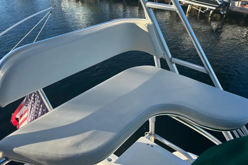 Slide: The Image of 2000 Pursuit 3400 Express boat docked by palm trees in a sunny marina. - 7