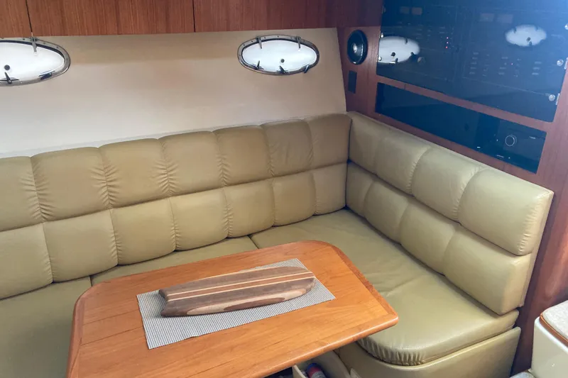 Slide: The Image of Electrical panel behind dinette. Dinette with storage under, port lights - 15