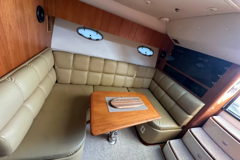 Slide: The Image of 1999 Tiara Yachts 3500 Open interior with light green leather seating and teak table. - 16