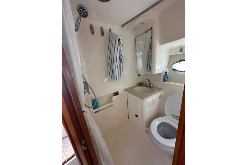 Slide: The Image of Bathroom interior of 1999 Tiara Yachts 3500 Open, featuring sink, toilet, and shower. - 18