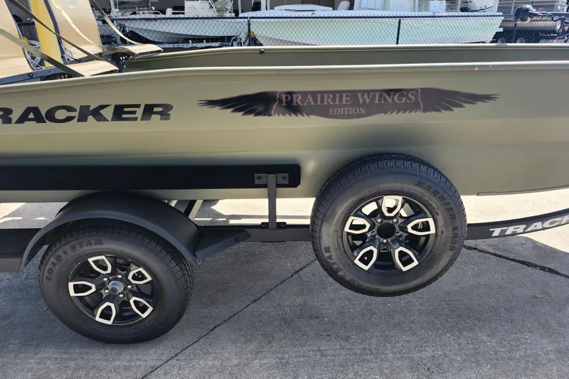 Slide: The Image of 2025 Tracker Grizzly 1650 T Prairie Wings Edition boat on trailer, showcasing stylish wheels. - 6