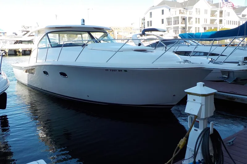 The Image of 2009 Tiara Yachts 3900 Open docked at marina, surrounded by other boats. - 0