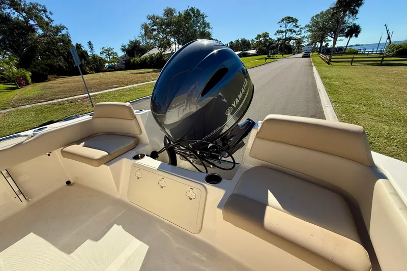Slide: The Image of 2026 Scout 195 Sportfish boat with Yamaha engine, parked on a sunny street. - 10
