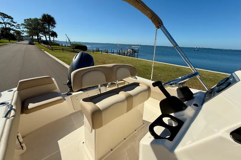Slide: The Image of 2026 Scout 195 Sportfish boat interior with seating, near a scenic waterfront. - 12