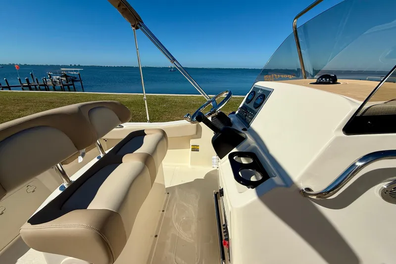 Slide: The Image of 2026 Scout 195 Sportfish boat interior with steering wheel, seats, and ocean view. - 20