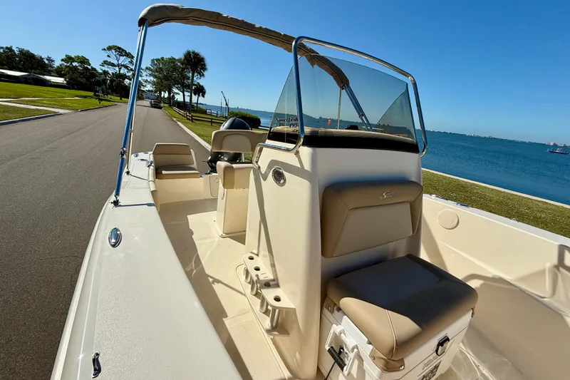 Slide: The Image of 2026 Scout 195 Sportfish boat with seating, near a scenic waterfront. - 21