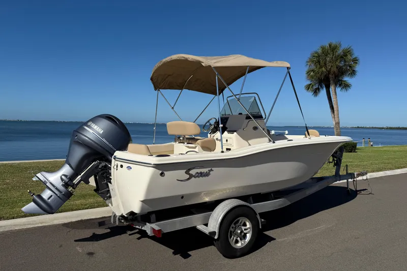 Slide: The Image of 2026 Scout 195 Sportfish boat on trailer by waterfront, featuring Yamaha outboard motor. - 4