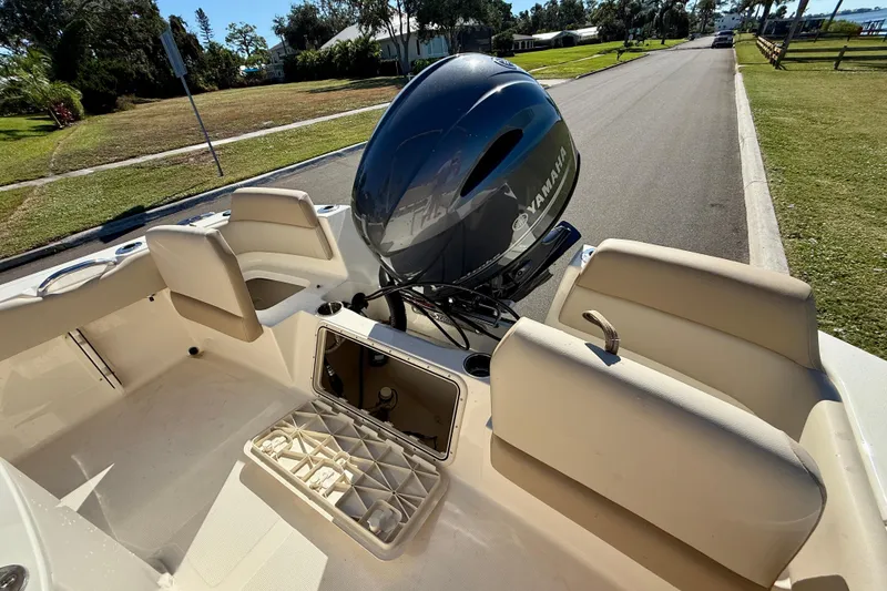 Slide: The Image of 2026 Scout 195 Sportfish boat with Yamaha engine, parked on a sunny street. - 9