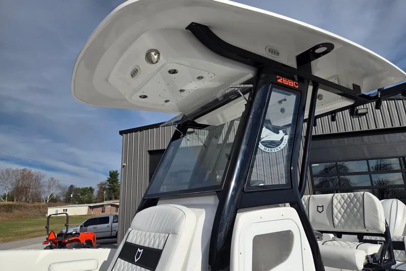 Slide: The Image of 2026 Sea Fox 268 Commander boat with T-top and cushioned seating, outdoors. - 7