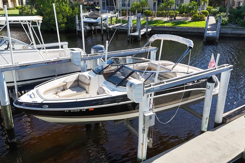 Slide: The Image of 2014 Formula 240 Bowrider boat docked in a marina, featuring sleek design and comfortable seating. - 10