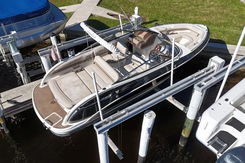Slide: The Image of 2014 Formula 240 Bowrider boat docked on a lift, featuring spacious seating and sleek design. - 11
